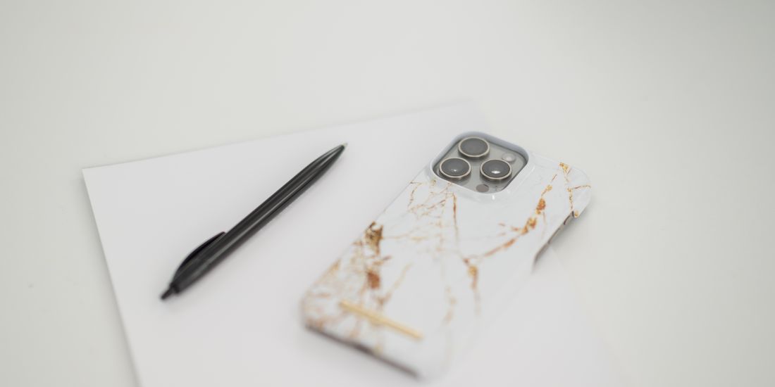 Mobiltelefon och anteckningsblock på ett skrivbord hos VHA Redovisning
