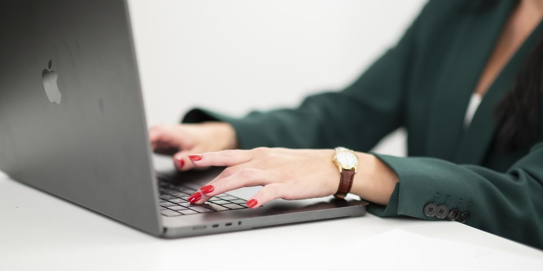 Närbild på händer som sköter löpande bokföring i ett digitalt bokföringssystem